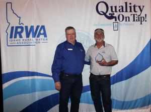 IRWA President Robert Dial poses for a photo with City of Challis representative Corey Rice in front of an IRWA banner at the IRWA Awards Banquet on April 2nd, 2026.