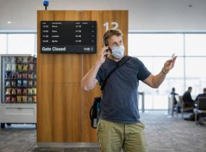 man at airport deciding on international travel for addiction treatment abroad