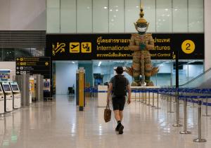person walking through airport departure area traveling abroad for rehab treatment