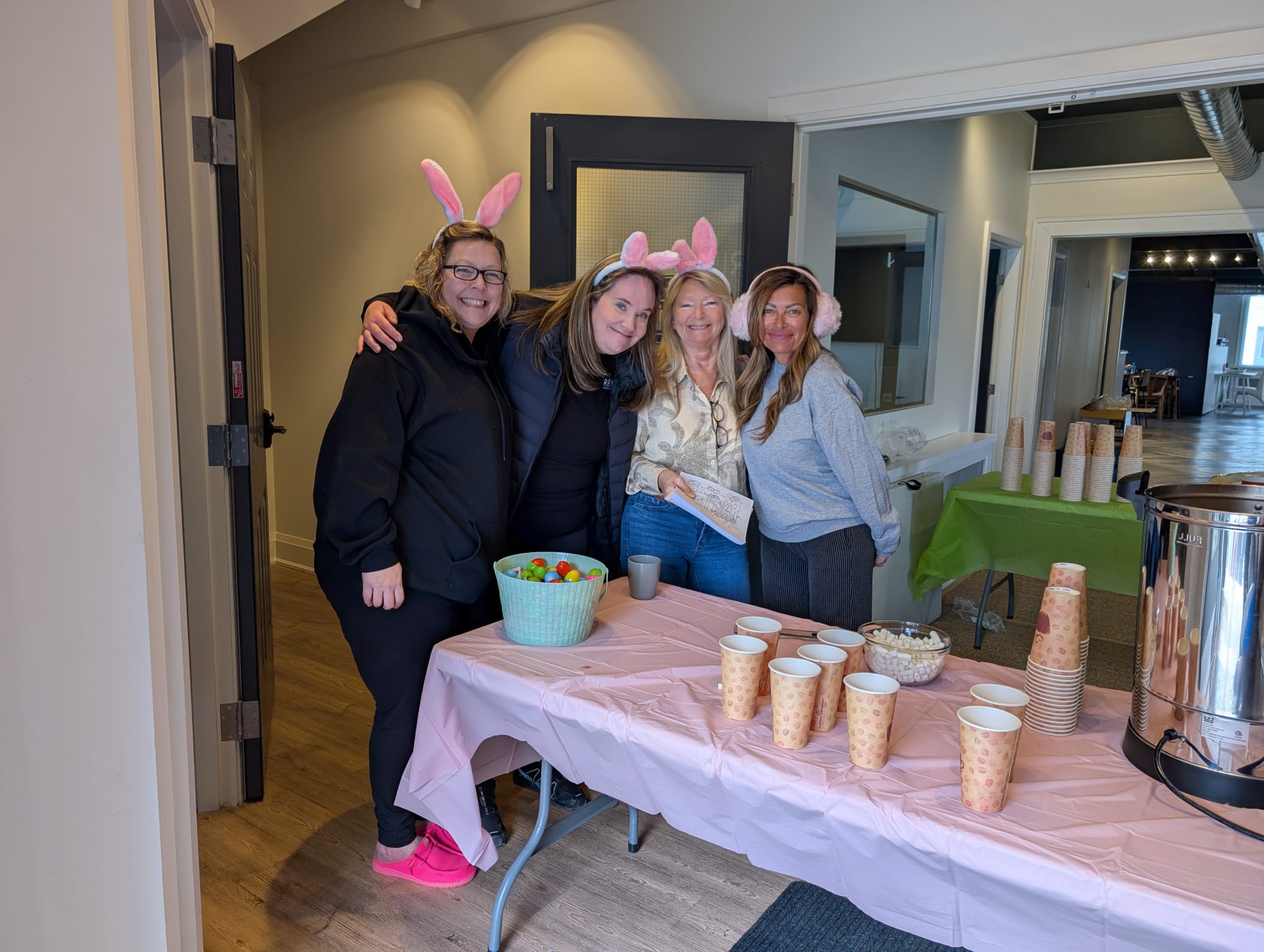 REMAX Hendriks Team Realty team members wearing festive bunny ears while hosting the St. Catharines community Easter event indoors.