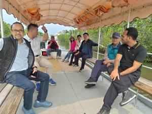 UN officials on a boat touring mangrove wetlands in Beimen, Taiwan, observing blue carbon ecosystems and coastal habitats.