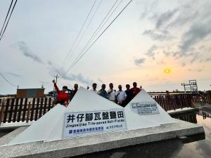 UN experts visiting a traditional salt-making site at the Jingzaijiao salt fields in Tainan, observing the production area and cultural preservation efforts.  我比較喜歡這個回應