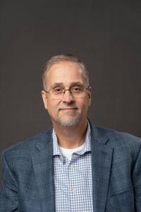 Richard Bruyere of IntraTEM headshot in blue suit with gray background
