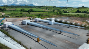 three rotors are seen on the ground in the wind park. Each rotor blade root is covered by working tents where the blade root remanufacturing is carried out