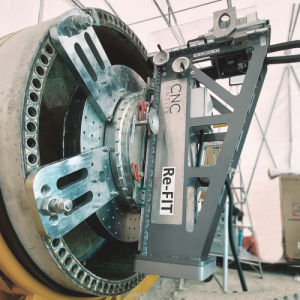 The CNC Onsite precision machine is seen fixed to the end of the rotor blade root ready to drill out defect bushings