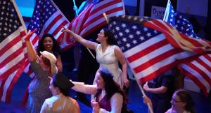 A group af cast members waving American flags