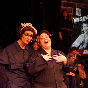 Two female factory workers share conversation