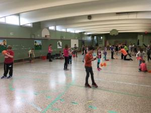 Enfants participant à un atelier de jonglerie avec diabolos dans un gymnase scolaire au Québec