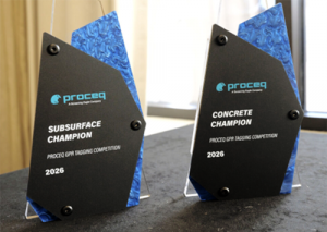 Two freestanding, asymmetrical glass trophies with black fronts and blue marbled sides rest on a dark table near a window; both display the Proceq logo and text reading “Subsurface Champion” and “Concrete Champion,” awarded for the Proceq GPR Tagging Comp