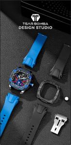 Tsar Bomba watch with blue and black case surrounded by interchangeable straps, bezels, and components arranged on a black textured surface.