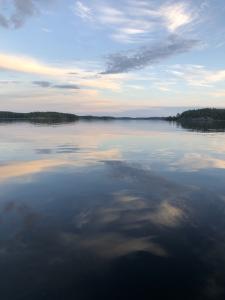 Clouds reflect on the still surface of a lake on a summer day.