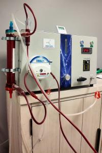 Trigen Kaizen EBOO machine used at Confidia Health Institute in Bristol, Connecticut, showing a blood filtration system with tubing, a chamber, and control panel for oxygenation and ozonation therapy.