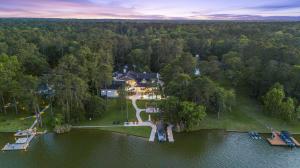 Aerial view of a private waterfront estate on two wooded acres with dock and shoreline on Indigo Lake in Magnolia, Texas.