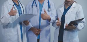 photo of various health care professionals in white lab coats all with their thumbs up
