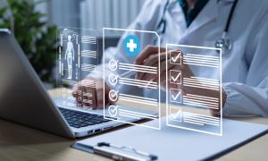 photo of a health care professional at a lap top reviewing quality management reports