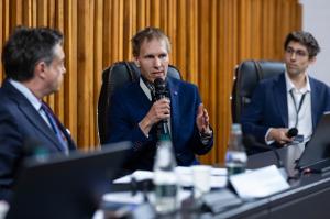 Jan Kára during the panel “Post-Quantum Security and Critical Systems.” From left to right: Gabriele Pao-Pei Andreoli, Jan Kára, and Utku Tefek.
