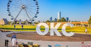 Daytime view of downtown Oklahoma City with the OKC landmark sign and skyline in the background.