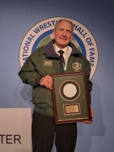 Paul Gilbert holding award plaque after green jacket ceremony at National Wrestling Hall of Fame Pennsylvania Chapter Outstanding American induction.
