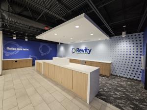 Interior wall graphic for Revity Credit Union featuring colorful branded graphics and acrylic logo elements inside a Greensboro workplace.