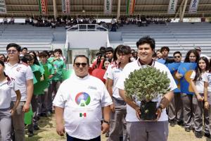 Young people carry a tree to the center of the football field in Mexico as part of a Fair Play Peace Circle® ritual before a match.