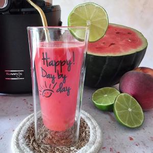 Fresh watermelon juice made with a Kuvings slow juicer, garnished with lime slices