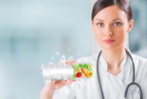 photo holistic nurse with a stethescope white uniform carrying a very large pill capsule filled with fruits and vegetables