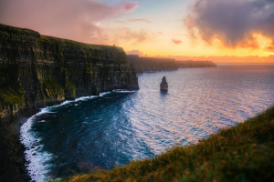 A dramatic sunset over the Cliffs of Moher in Ireland, featuring steep rugged cliffs and the Atlantic Ocean, representing the high life quality metrics used in the 2026 PassportRanking for Stamp 0 residency planning.