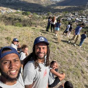 The team from Grace Community Church are on the top of a high hill with International Samaritan scholarship students overlooking their community in Tegucigalpa, Honduras, next to the dumpsite.