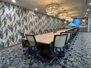 Modern boardroom on the 4th floor of Two Doral with large conference table, seating for 28, and a 100 inch presentation screen.