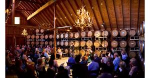 People sitting in the round inside Barrel Room with musicians playing in the center.