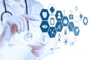 photo a health care manager pointing on a large digital screen to many icons related to the tenets of management