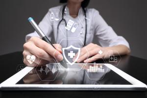 photo of a health care manager seated looking over an ipad working on management documents