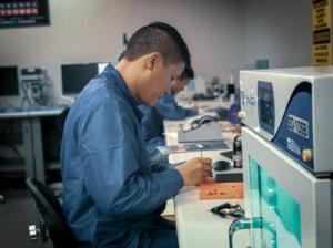Technician inspecting semiconductor components in Vyrian’s ISO-certified testing laboratory