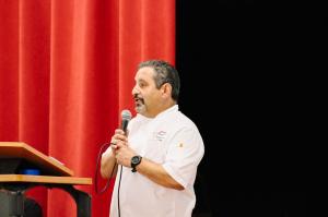 Chef Serge Krikorian, Executive Chef and Managing Partner of Vibrant Occasions Catering, addresses students at Glen Rose High School during the company's heart leadership presentation.