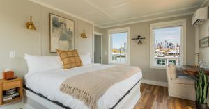 FLOHOM 16 Isaac's Way bedroom with brass sconces dedicated workspace and windows overlooking marina and Lower Manhattan skyline
