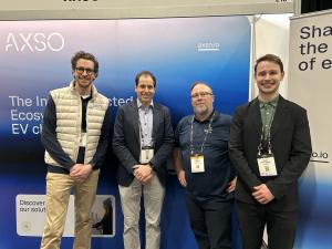 From left to right: Vincent (AXSO), Simon Pilarella (ChargeHub CEO), Martin Archambault (Hydro-Québec, Circuit électrique), and Tristan Williams-Choquette (ChargeHub) standing together in front of the AXSO booth at an EV industry trade show.