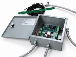FailSafe Alignment System hardware: a gray metal control enclosure opened to show a green circuit board with terminal blocks and armored cable conduits, alongside a slim green sill-mounted sensor strip.
