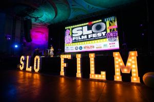 Stage of the Fremont Theater with illuminated letters spelling out SLO FILM. Credit Brittany App