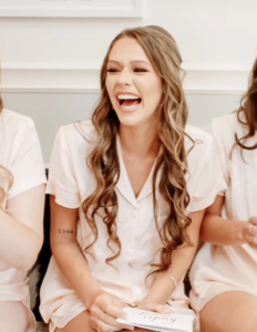 Young woman smiling and laughing indoors in a candid moment.