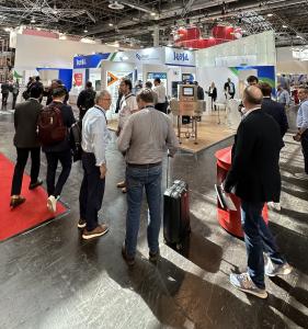 Brazil’s booth at Interpack, featuring the visual identity of Brazil Machinery Solutions, in an international trade fair setting. The space is modern and open, with panels in blue, white, and green displaying the “Brazil” brand. Visitors move through the