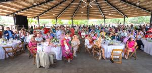 Guests at NTRC’s Kentucky Derby Party gather under the covered arena, dressed in colorful Derby attire and festive hats as they watch the race together.