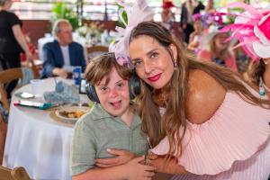 Colton, the evening’s featured program participant, smiles with sponsor Colleen Kravis during Naples Therapeutic Riding Center’s Kentucky Derby Party.