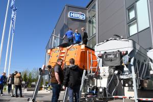 People standing in front of new equipment at a manufacturing plant.