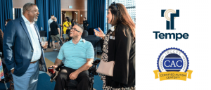 Three people engaged in conversation at an indoor event; two logos to the right, one for Tempe and one for Certified Autism Center.
