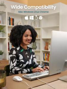 A woman smiles while working at a desktop computer in a home office setting. The PERIMICE-209CW white wired mouse and a matching white keyboard are on the desk in front of her. Text overlay reads "Wide Compatibility" with OS icons for Mac, Windows, Linux,
