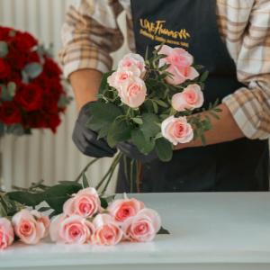 Florist arranging fresh pink roses by hand at UAE Flowers  for a luxury flower bouquet order in the UAE.