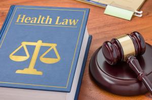 photo of a health care law text book with the scales of justice beside it