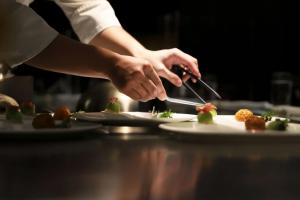 Image of a chef's hands plating a tasting dish at a luxury fine dining restaurant.