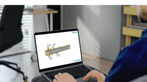 Person using a laptop to view a 3D industrial mechanical system diagram in a modern office environment.