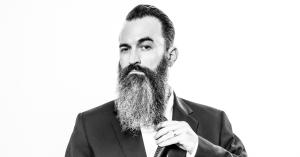 Comedian and filmmaker Jon Schnitzer with a long beard wearing a suit and adjusting his tie. Something Spooky is about his grandmothers imaginary friend who turned out to be not so imaginary. Scream and laugh with strangers in the dark.